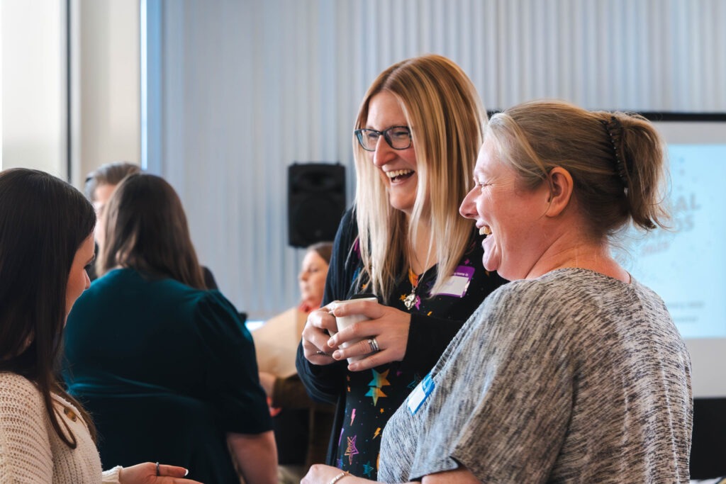 Two women laughing at business conversation